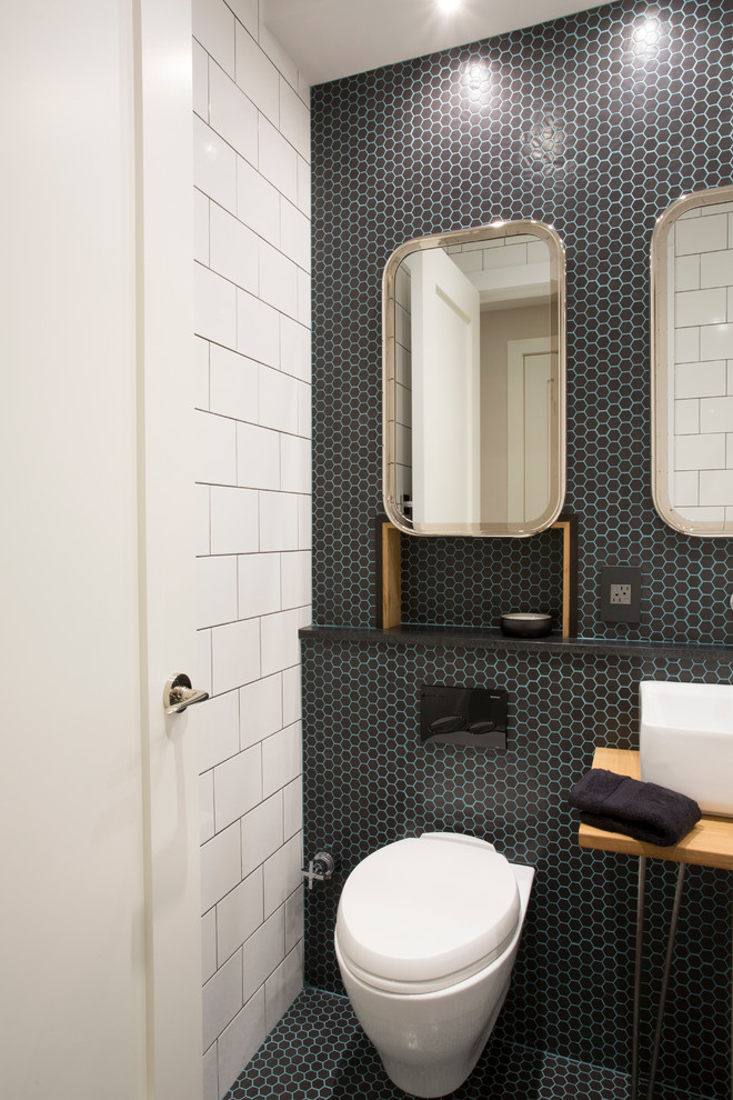 Пример оригинального дизайна: маленькая ванная комната в стиле неоклассика (современная классика) с накладной ванной, душем над ванной, инсталляцией, черной плиткой, стеклянной плиткой, черными стенами, полом из мозаичной плитки и настольной раковиной для на участке и в саду