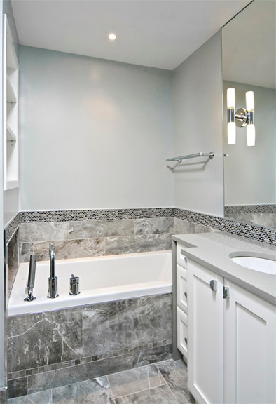 Bathroom - contemporary gray tile and porcelain tile bathroom idea in Ottawa with an undermount sink, recessed-panel cabinets, white cabinets, quartz countertops and a two-piece toilet