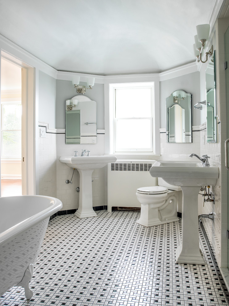 Klassisk inredning av ett badrum, med ett piedestal handfat, vit kakel, tunnelbanekakel, grå väggar och mosaikgolv
