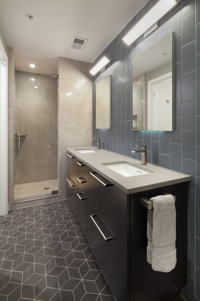 Пример оригинального дизайна: ванная комната среднего размера в современном стиле с плоскими фасадами, черными фасадами, унитазом-моноблоком, серой плиткой, плиткой кабанчик, полом из винила, душевой кабиной, врезной раковиной, душем в нише, серыми стенами и столешницей из искусственного камня