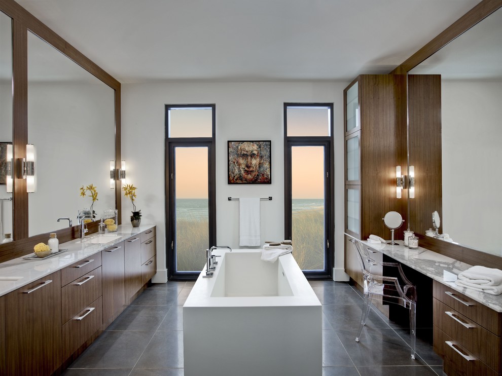 Exempel på ett mellanstort modernt en-suite badrum, med ett fristående badkar, ett undermonterad handfat, släta luckor, skåp i mellenmörkt trä, marmorbänkskiva, en kantlös dusch, grå kakel, keramikplattor och vita väggar