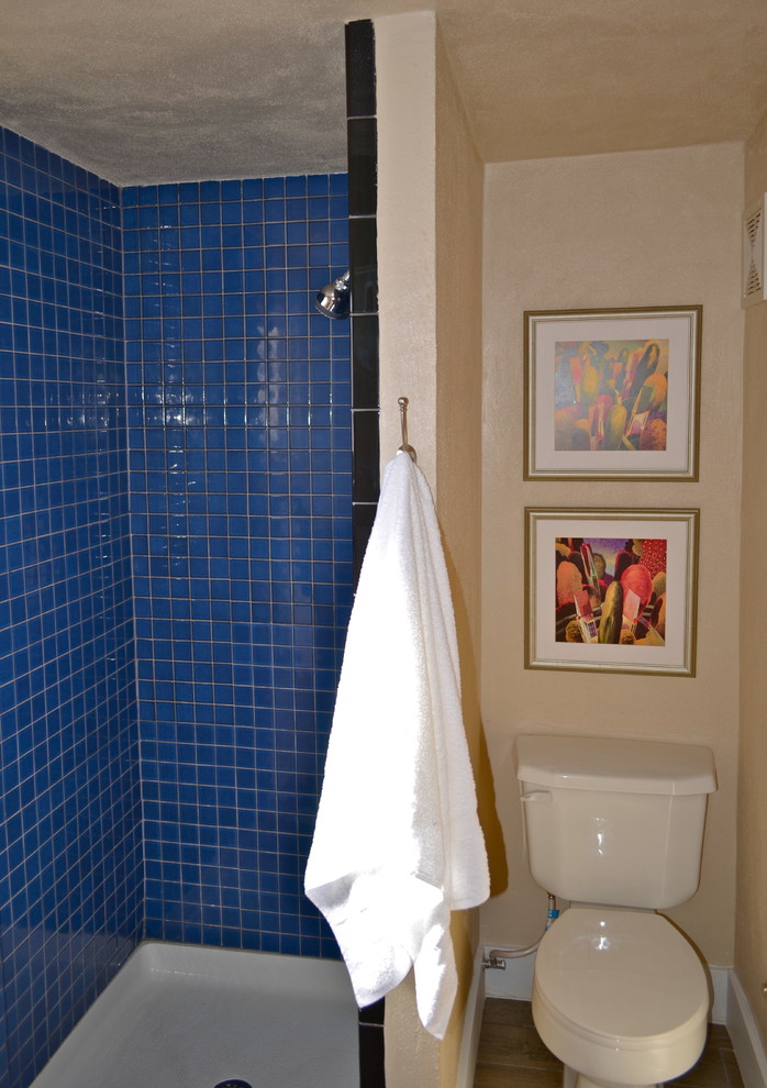 Bild på ett mellanstort vintage en-suite badrum, med släta luckor, skåp i mellenmörkt trä, en dusch i en alkov, en toalettstol med separat cisternkåpa, blå kakel, keramikplattor, vita väggar, klinkergolv i keramik, bänkskiva i akrylsten och ett piedestal handfat