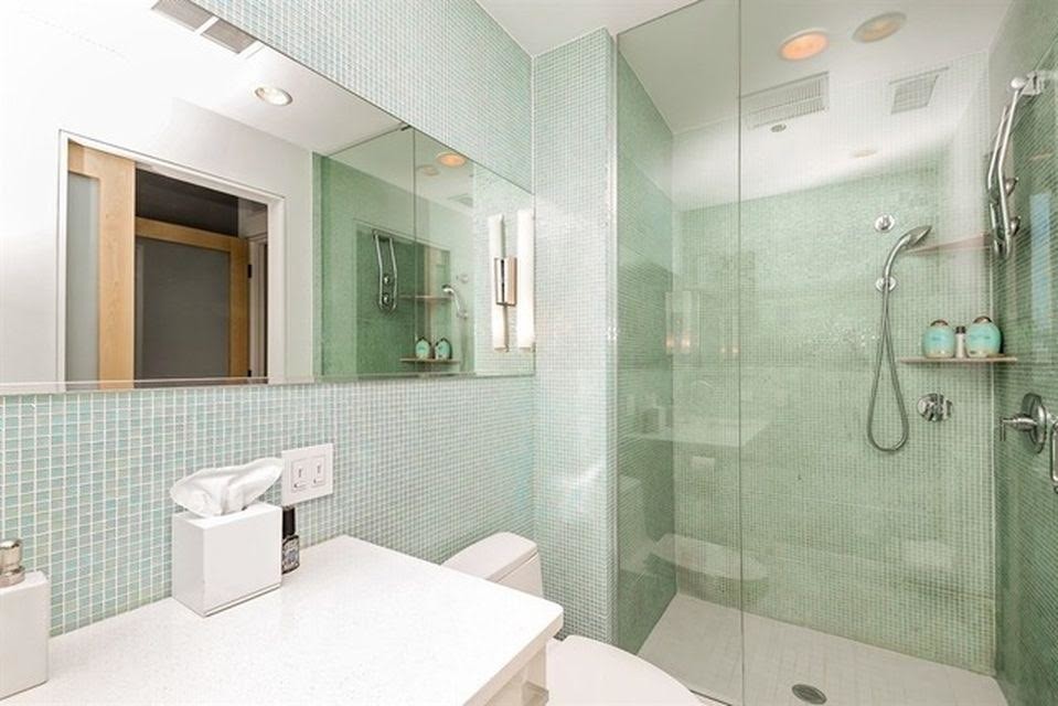 Bild på ett stort funkis badrum med dusch, med vita skåp, en hörndusch, en toalettstol med hel cisternkåpa, ett undermonterad handfat, släta luckor, vit kakel, grön kakel, vita väggar, vinylgolv, granitbänkskiva, mosaik, vitt golv och dusch med gångjärnsdörr
