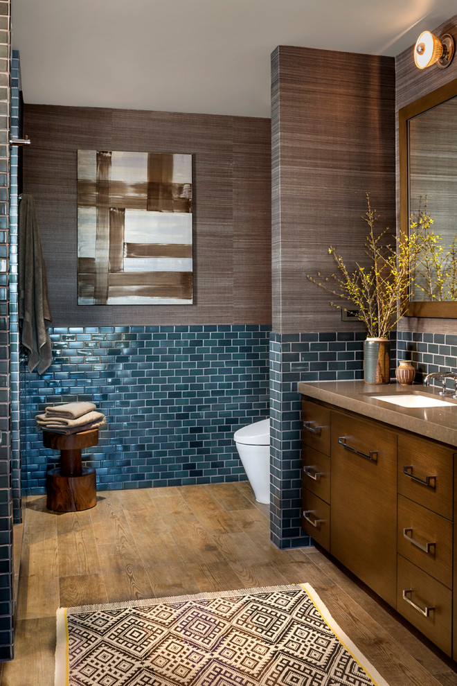 Идея дизайна: ванная комната в современном стиле с плоскими фасадами, темными деревянными фасадами, синей плиткой, плиткой кабанчик, разноцветными стенами, врезной раковиной, коричневой столешницей, паркетным полом среднего тона, встроенной тумбой и обоями на стенах