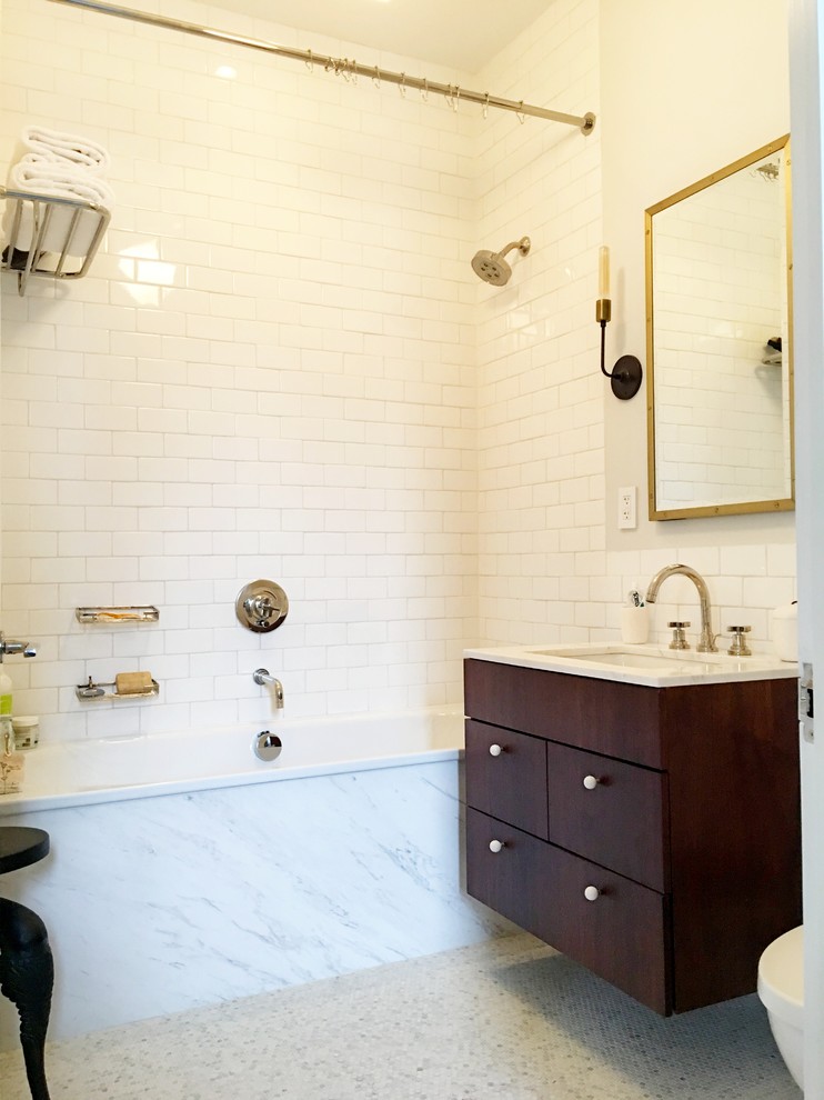 Inspiration for a 1960s master white tile and subway tile marble floor drop-in bathtub remodel in New York with flat-panel cabinets, dark wood cabinets, a one-piece toilet, an undermount sink and quartz countertops