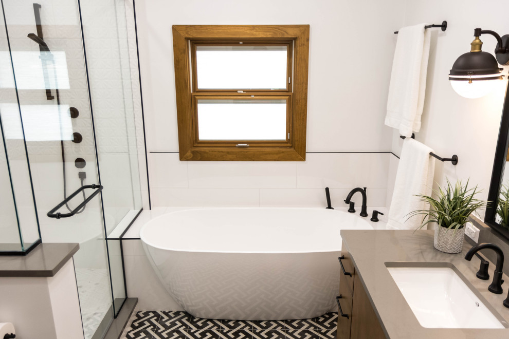 This is an example of a medium sized midcentury ensuite bathroom in Orlando with flat-panel cabinets, medium wood cabinets, a freestanding bath, white tiles, porcelain tiles, white walls, porcelain flooring, a submerged sink, engineered stone worktops, multi-coloured floors and grey worktops.