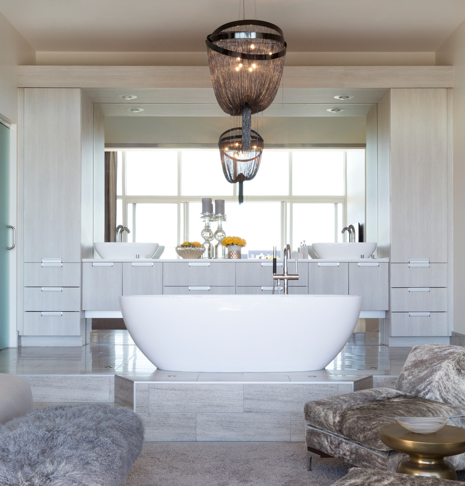 Свежая идея для дизайна: большая главная ванная комната в современном стиле с плоскими фасадами, серыми фасадами, настольной раковиной, столешницей из искусственного кварца, отдельно стоящей ванной и бежевыми стенами - отличное фото интерьера