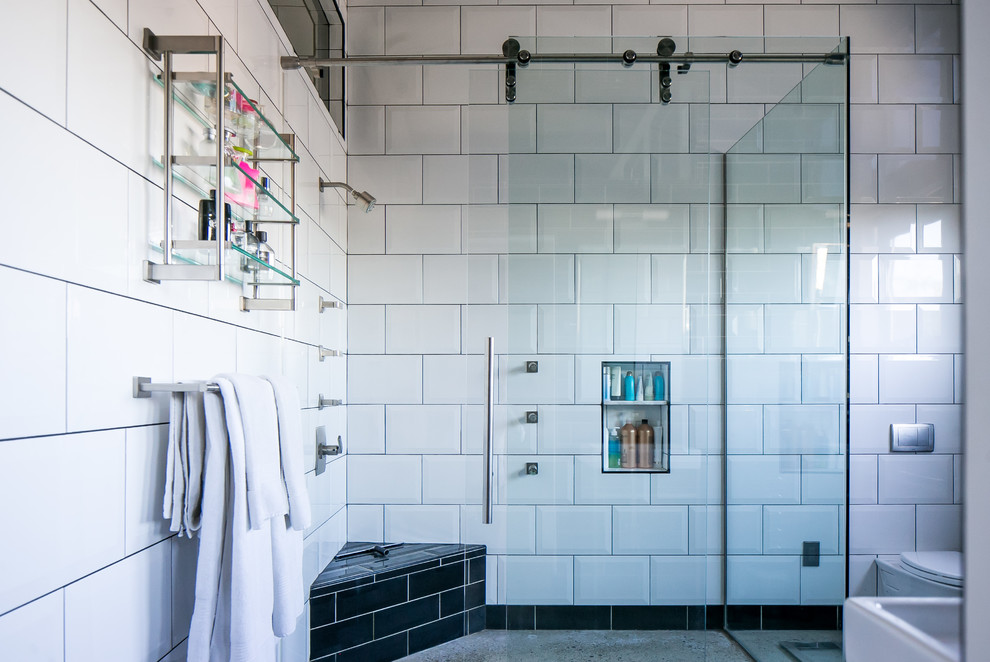 Bild på ett mellanstort industriellt badrum med dusch, med möbel-liknande, skåp i slitet trä, en hörndusch, en vägghängd toalettstol, tunnelbanekakel, betonggolv, ett väggmonterat handfat, grått golv och dusch med skjutdörr