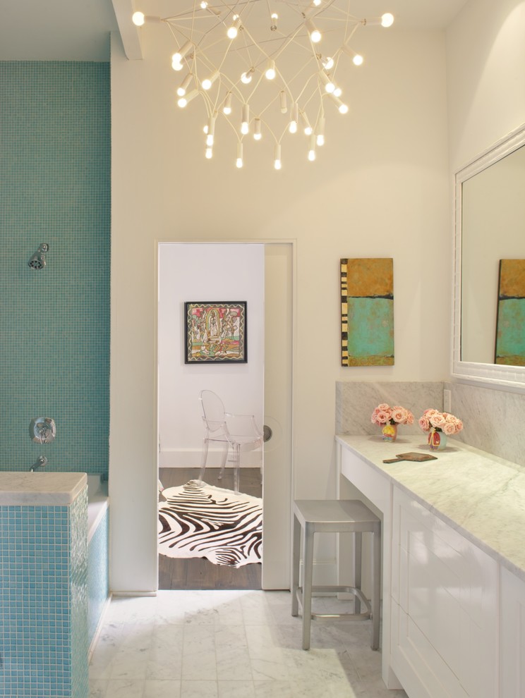 Foto di una stanza da bagno minimalista con vasca ad alcova, vasca/doccia, piastrelle blu e piastrelle a mosaico