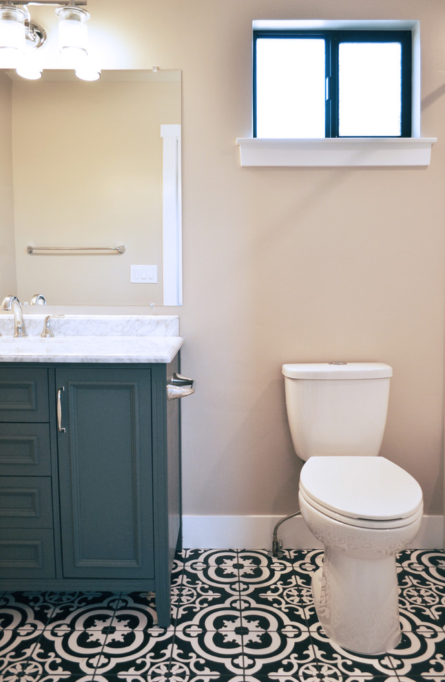 Inspiration for a small mediterranean master porcelain tile and black floor bathroom remodel in San Luis Obispo with recessed-panel cabinets, gray cabinets, a two-piece toilet, beige walls, an undermount sink, marble countertops and white countertops