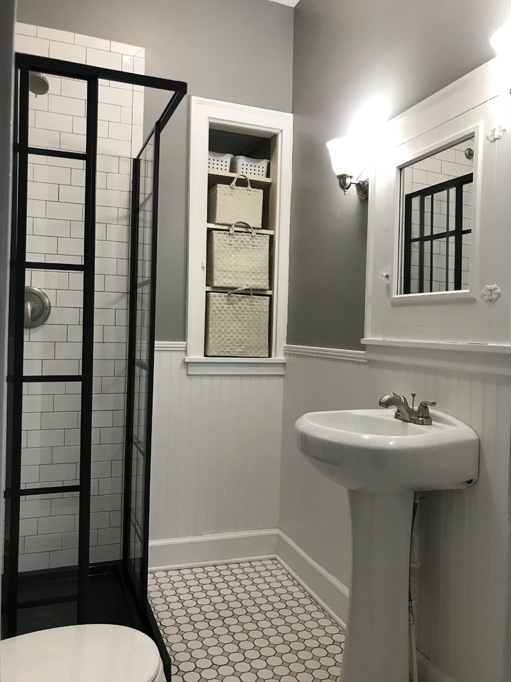 Foto på ett litet vintage en-suite badrum, med en hörndusch, vit kakel, mosaik, grå väggar, ett piedestal handfat, flerfärgat golv och dusch med skjutdörr