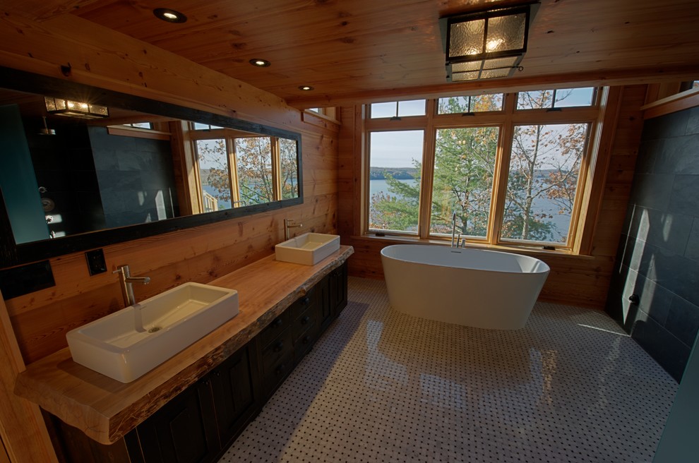 Foto di una grande stanza da bagno padronale rustica con ante in legno bruno, vasca freestanding, pavimento in marmo, lavabo a bacinella e top in legno