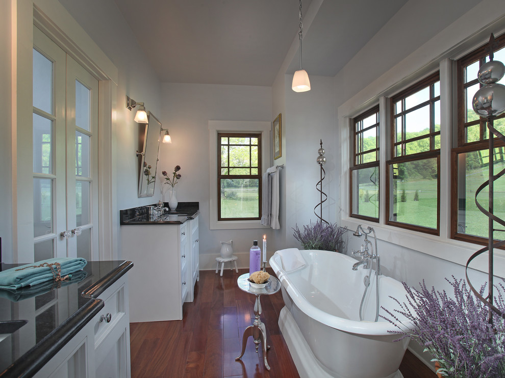 Diseño de cuarto de baño largo y estrecho clásico de tamaño medio con bañera exenta y lavabo bajoencimera