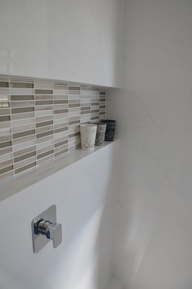 Свежая идея для дизайна: ванная комната в современном стиле с монолитной раковиной, открытым душем, унитазом-моноблоком, плоскими фасадами, белыми фасадами, столешницей из искусственного камня, белой плиткой и керамогранитной плиткой - отличное фото интерьера