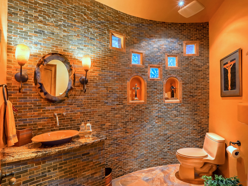 Imagen de cuarto de baño de estilo americano pequeño con sanitario de una pieza, baldosas y/o azulejos marrones, baldosas y/o azulejos de piedra, paredes beige, suelo de travertino, lavabo sobreencimera, encimera de granito y suelo beige