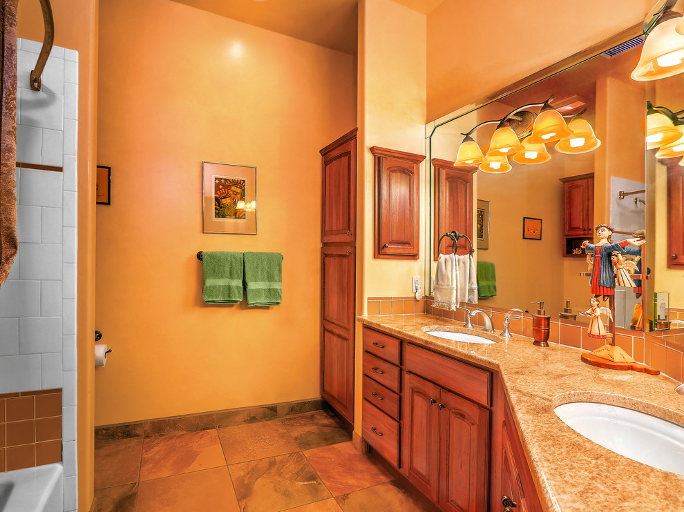 Idées déco pour une salle de bain sud-ouest américain en bois brun de taille moyenne avec un placard avec porte à panneau encastré, un carrelage rouge, un plan de toilette en granite et un plan de toilette marron.