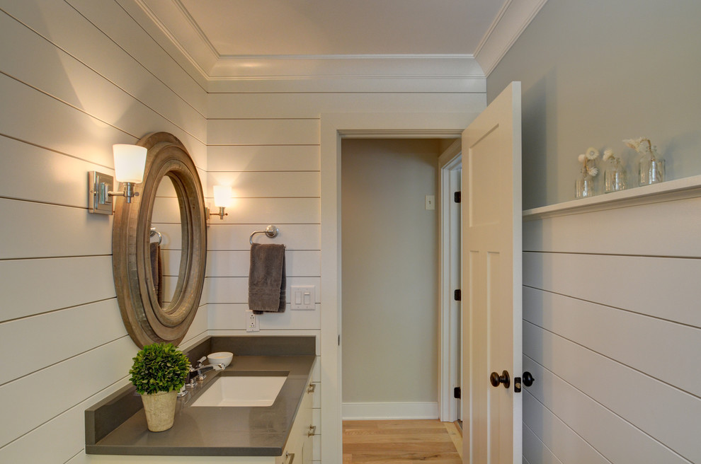 Exemple d'une salle de bain craftsman de taille moyenne avec un placard à porte plane, des portes de placard beiges, WC séparés, un mur beige, un sol en bois brun et un lavabo encastré.