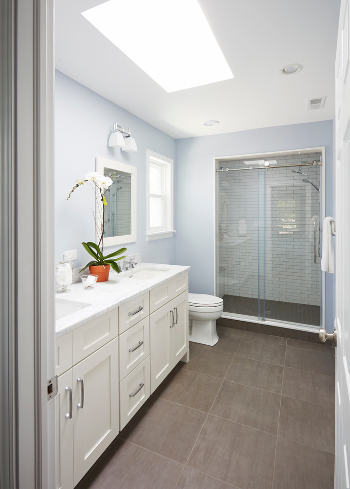 Идея дизайна: главная ванная комната среднего размера в стиле неоклассика (современная классика) с фасадами в стиле шейкер, белыми фасадами, керамогранитной плиткой, синими стенами, врезной раковиной, мраморной столешницей, полом из керамогранита, раздельным унитазом, душем в нише и белой плиткой