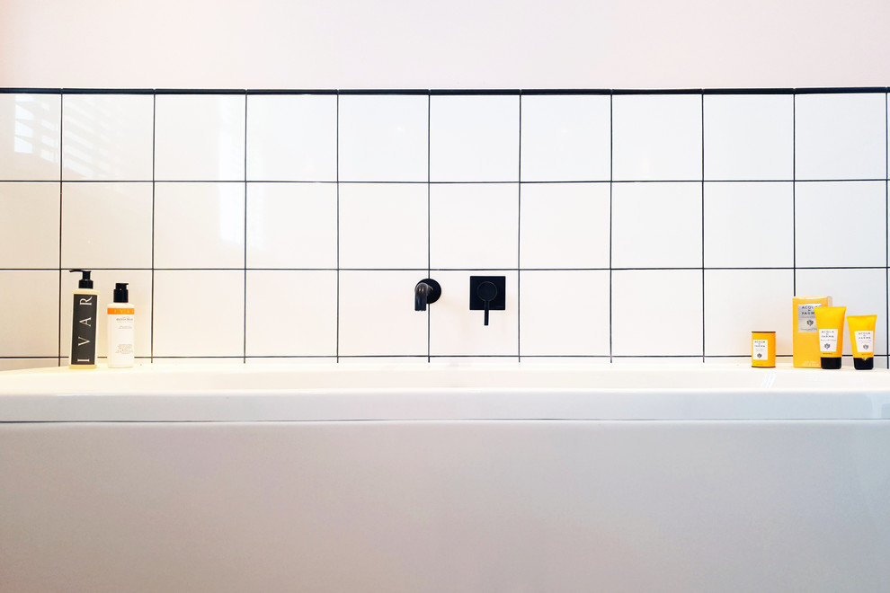 Doorless shower - small contemporary 3/4 white tile and ceramic tile ceramic tile and gray floor doorless shower idea in London with furniture-like cabinets, black cabinets, a wall-mount toilet, pink walls, a wall-mount sink, a hinged shower door and white countertops