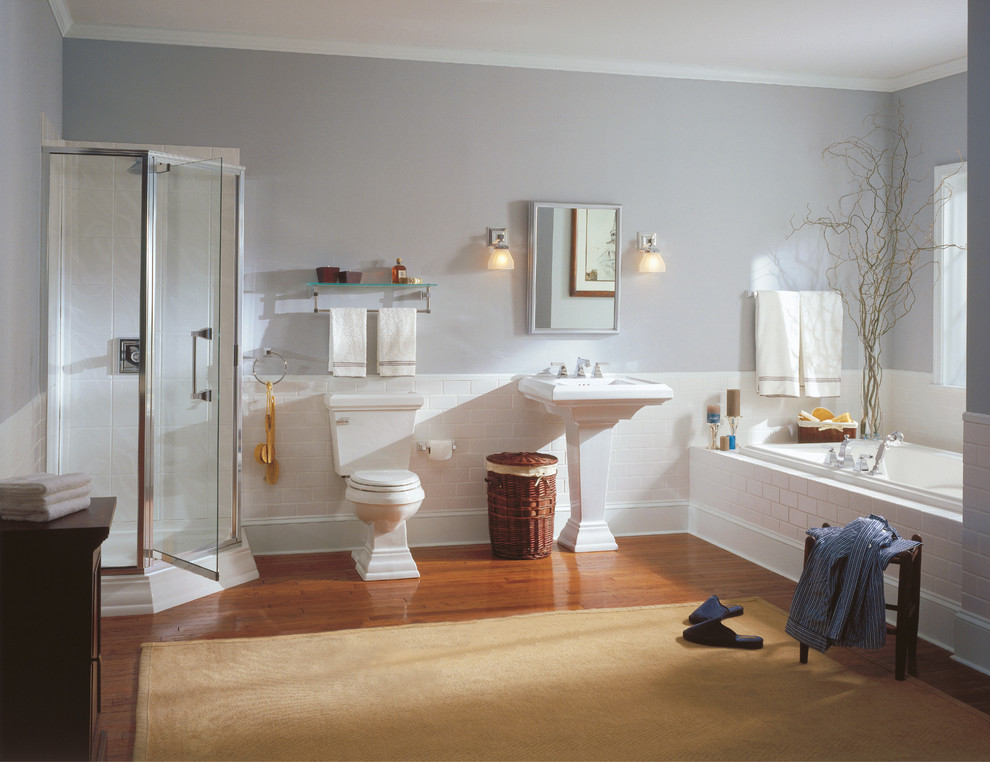 На фото: главная ванная комната в классическом стиле с отдельно стоящей ванной, унитазом-моноблоком, полом из терракотовой плитки, угловым душем, белой плиткой, плиткой кабанчик, серыми стенами, раковиной с пьедесталом, коричневым полом и душем с распашными дверями с