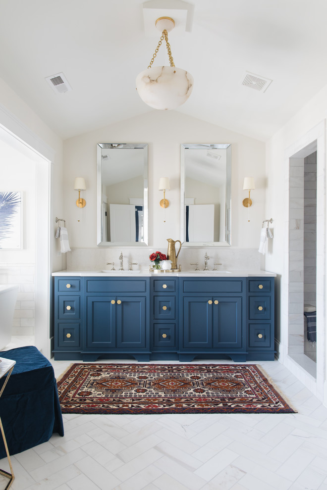 Exemple d'une douche en alcôve principale chic avec un placard à porte shaker, des portes de placard bleues, une baignoire indépendante, un carrelage gris, un carrelage blanc, du carrelage en marbre, un mur blanc, un sol en marbre, un lavabo encastré, un sol gris et aucune cabine.