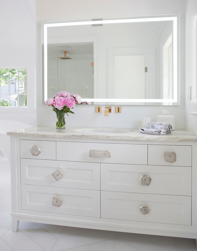 Inspiration for a huge transitional master white tile and marble tile marble floor and white floor bathroom remodel in New York with recessed-panel cabinets, white cabinets, a wall-mount toilet, white walls, an undermount sink, marble countertops and a hinged shower door