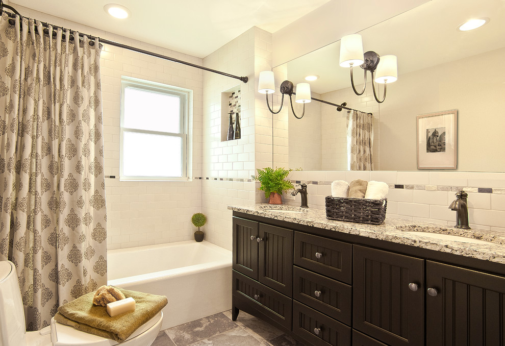 This is an example of a classic bathroom in Milwaukee with a submerged sink, dark wood cabinets, an alcove bath, a shower/bath combination, white tiles, metro tiles and white walls.