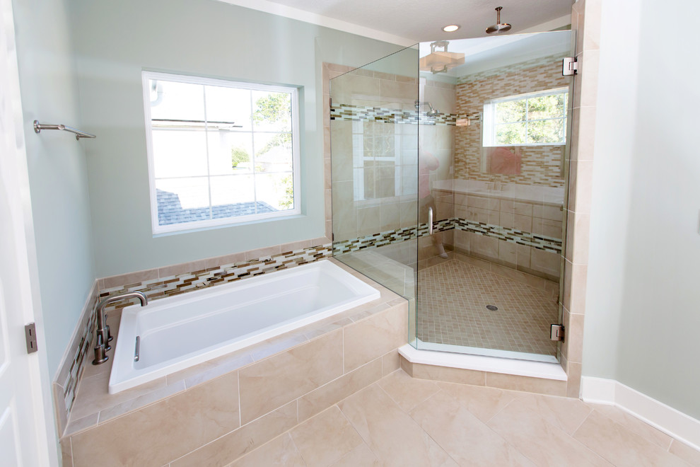 Beach style beige tile bathroom photo in Jacksonville with an undermount sink, recessed-panel cabinets, white cabinets, solid surface countertops and a two-piece toilet