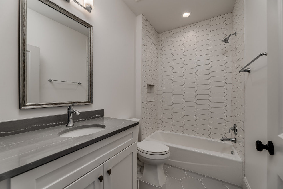 Large mediterranean family bathroom in Jacksonville with shaker cabinets, white cabinets, an alcove bath, an alcove shower, a two-piece toilet, white tiles, porcelain tiles, white walls, porcelain flooring, a submerged sink, engineered stone worktops, grey floors, grey worktops, a single sink and a built in vanity unit.