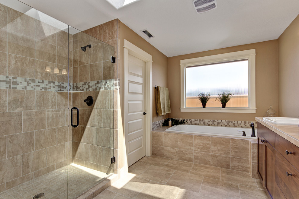 Example of a large classic master beige tile and ceramic tile ceramic tile bathroom design in Portland with shaker cabinets, medium tone wood cabinets, beige walls, a drop-in sink and tile countertops