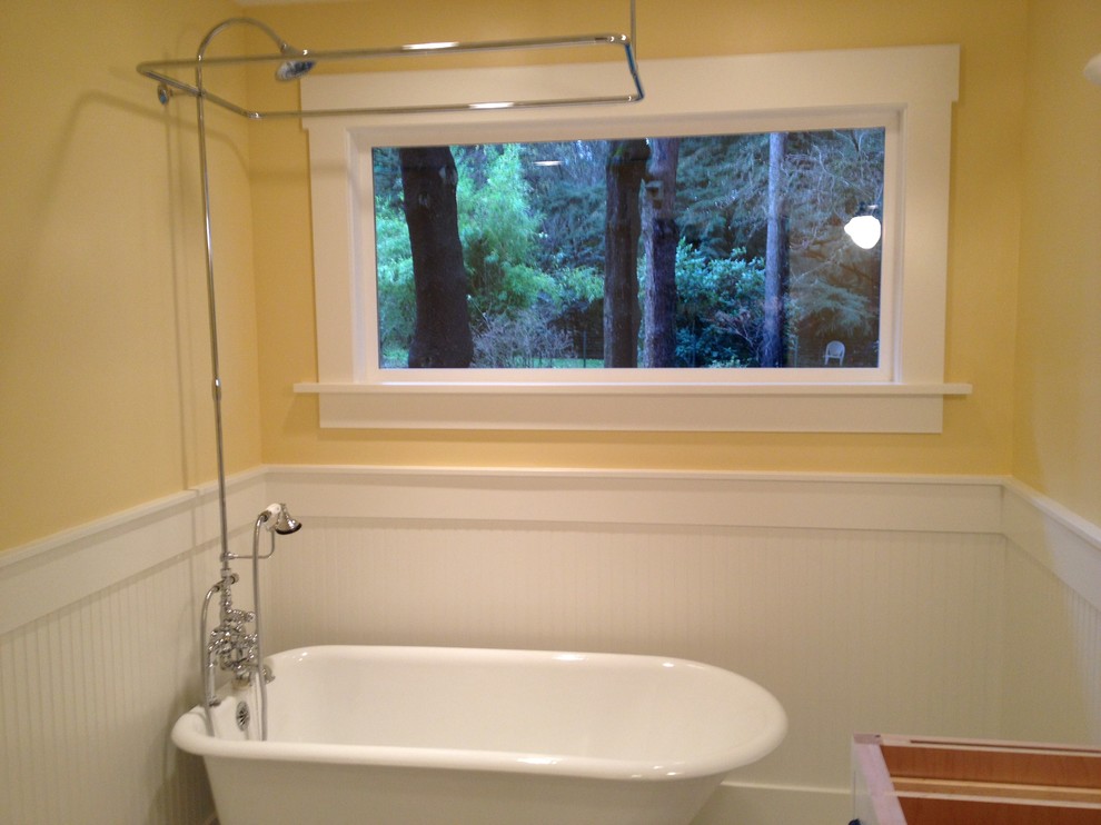 Exempel på ett litet klassiskt badrum med dusch, med luckor med profilerade fronter, vita skåp, ett badkar med tassar, en dusch/badkar-kombination och gula väggar