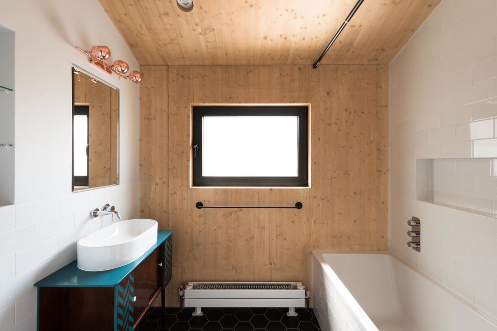 Ispirazione per una stanza da bagno etnica di medie dimensioni con ante lisce, ante marroni, vasca da incasso, lavabo a bacinella e pavimento nero