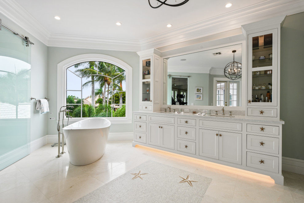 Ispirazione per una grande stanza da bagno tropicale con ante a filo, ante bianche, parquet chiaro e pavimento marrone