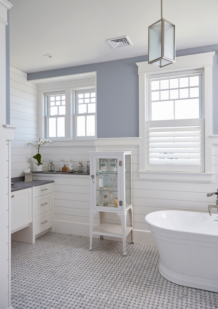 Inspiration for a large coastal ensuite bathroom in Providence with shaker cabinets, white cabinets, a freestanding bath, a two-piece toilet, a submerged sink, marble worktops, grey floors, grey worktops, a single sink, a built in vanity unit, tongue and groove walls, white walls and laminate floors.