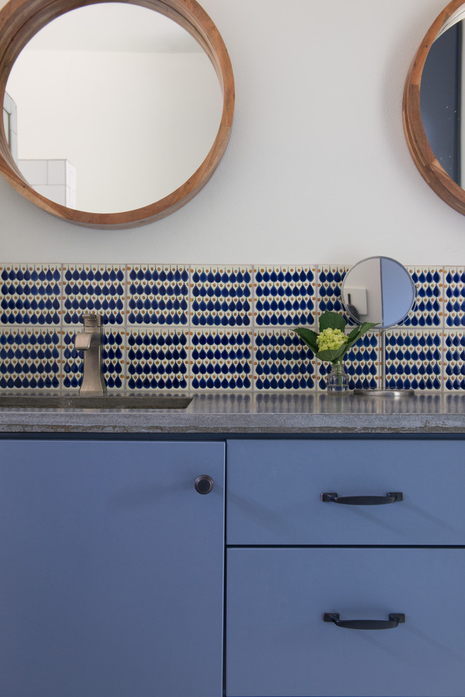 Пример оригинального дизайна: ванная комната среднего размера в стиле кантри с плоскими фасадами, синими фасадами, ванной в нише, душем над ванной, унитазом-моноблоком, белой плиткой, керамогранитной плиткой, белыми стенами, бетонным полом, душевой кабиной, врезной раковиной и столешницей из бетона