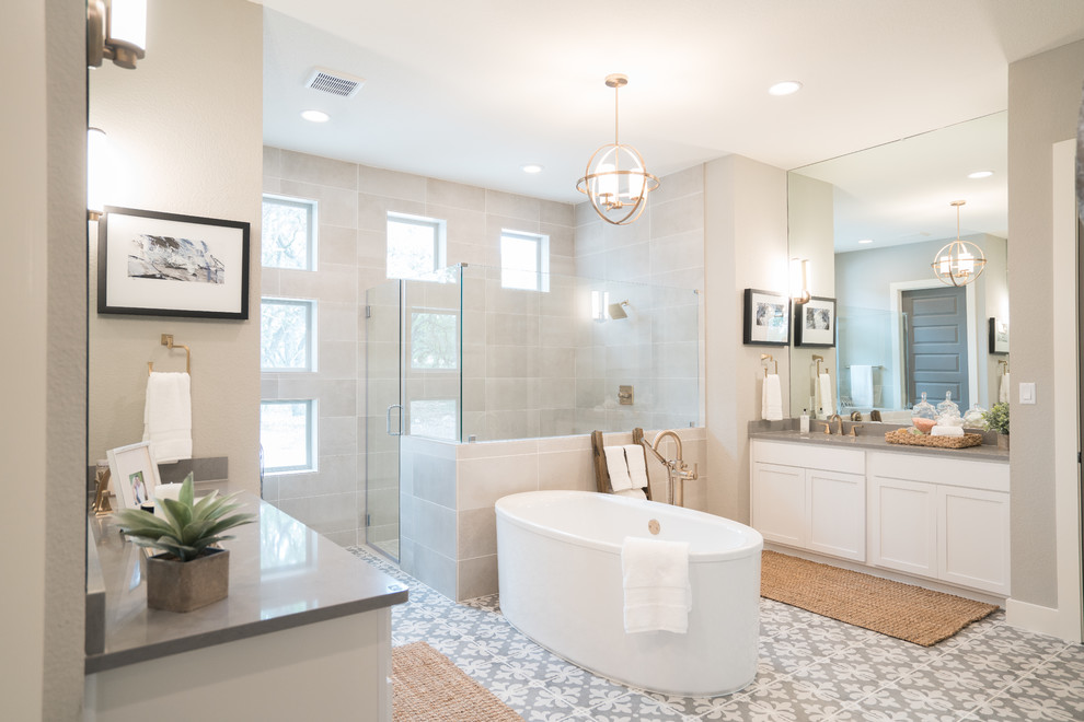 Пример оригинального дизайна: главная ванная комната среднего размера в стиле неоклассика (современная классика) с фасадами в стиле шейкер, белыми фасадами, отдельно стоящей ванной, угловым душем, серой плиткой, серыми стенами, серым полом, душем с распашными дверями, серой столешницей, унитазом-моноблоком, цементной плиткой, полом из керамической плитки, врезной раковиной и столешницей из искусственного кварца