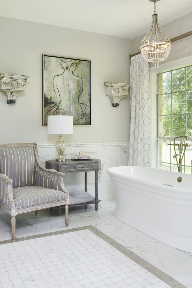 Foto på ett stort badrum, med ett fristående badkar, vit kakel och grå väggar
