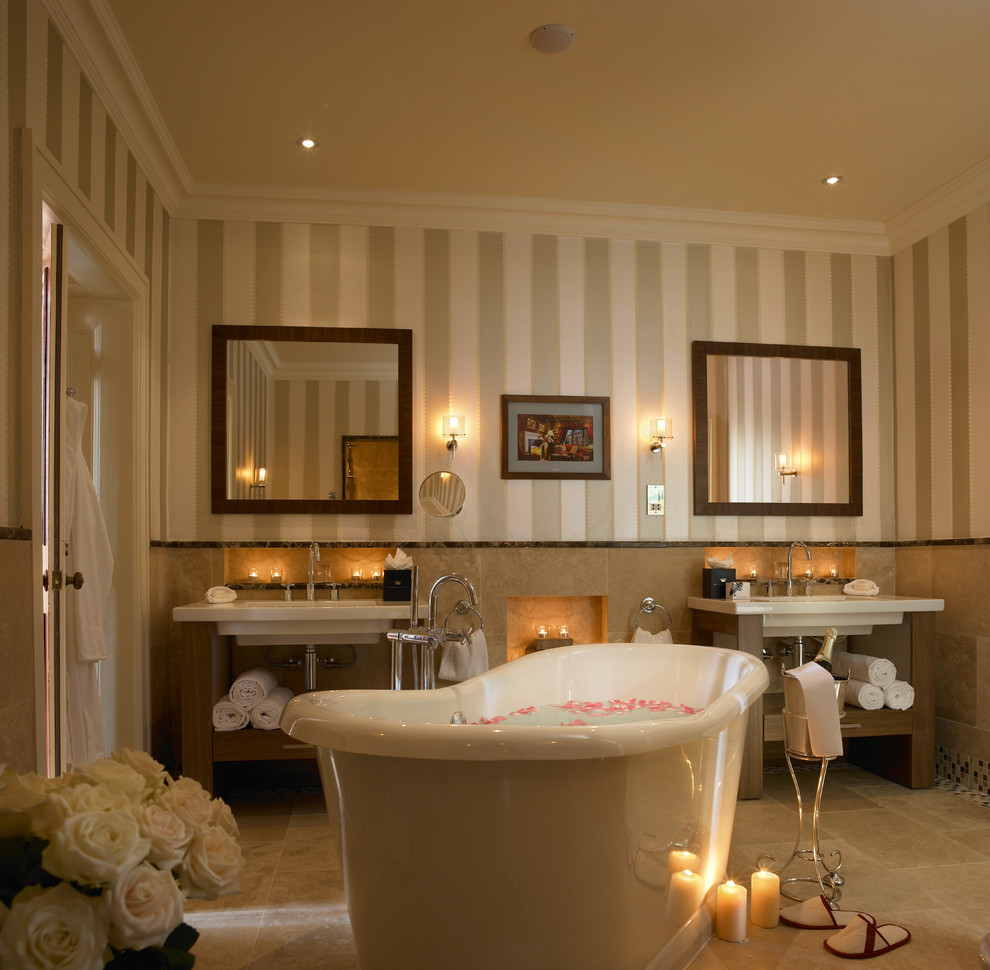 Mid-sized transitional beige floor freestanding bathtub photo in Other with beige walls and a console sink