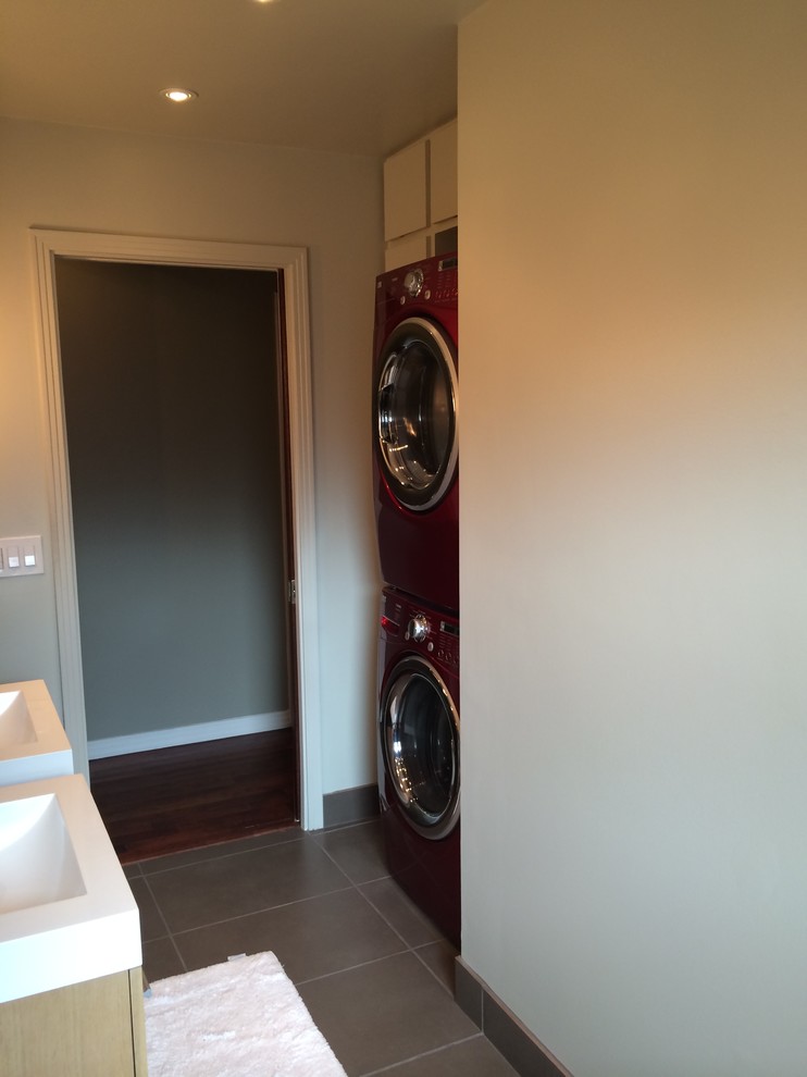 Esempio di una lavanderia minimalista di medie dimensioni con ante lisce, ante in legno chiaro e pavimento in gres porcellanato