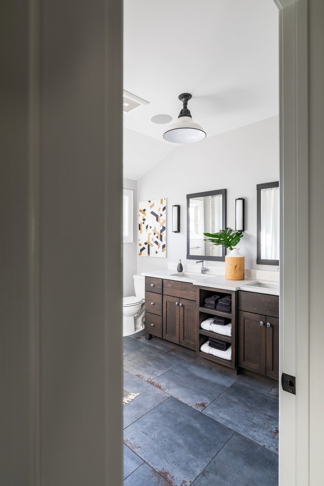 Photo of a large traditional bathroom in Chicago with shaker cabinets, brown cabinets, a two-piece toilet, grey walls, porcelain flooring, a submerged sink, engineered stone worktops, grey floors and white worktops.