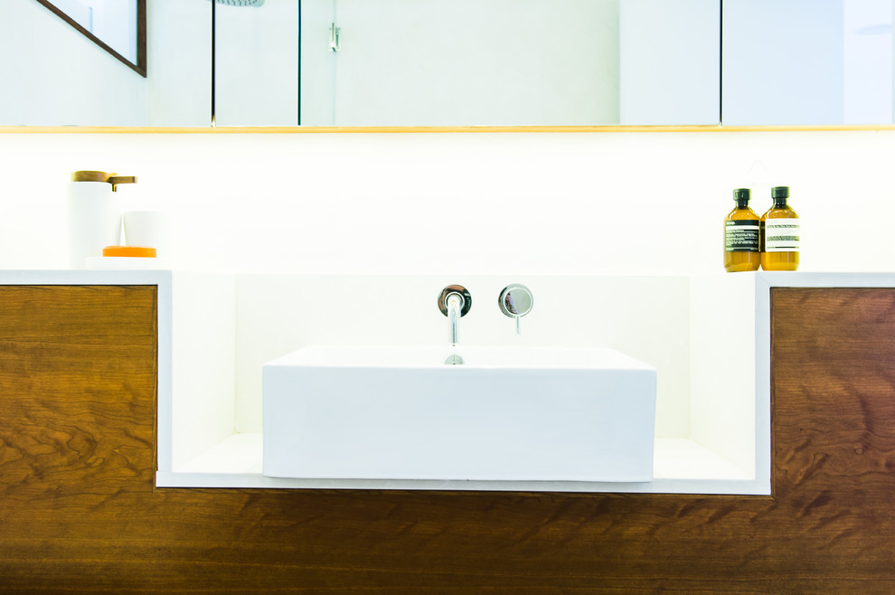 Esempio di una stanza da bagno padronale design di medie dimensioni con ante lisce, ante in legno scuro e top in quarzite