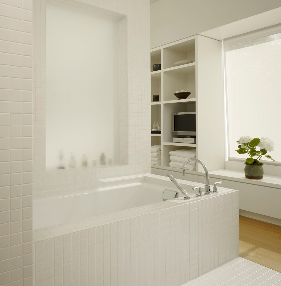 Idéer för ett stort modernt badrum med dusch, med släta luckor, vita skåp, bänkskiva i akrylsten, ett platsbyggt badkar, vit kakel, keramikplattor, en hörndusch, vita väggar och ljust trägolv