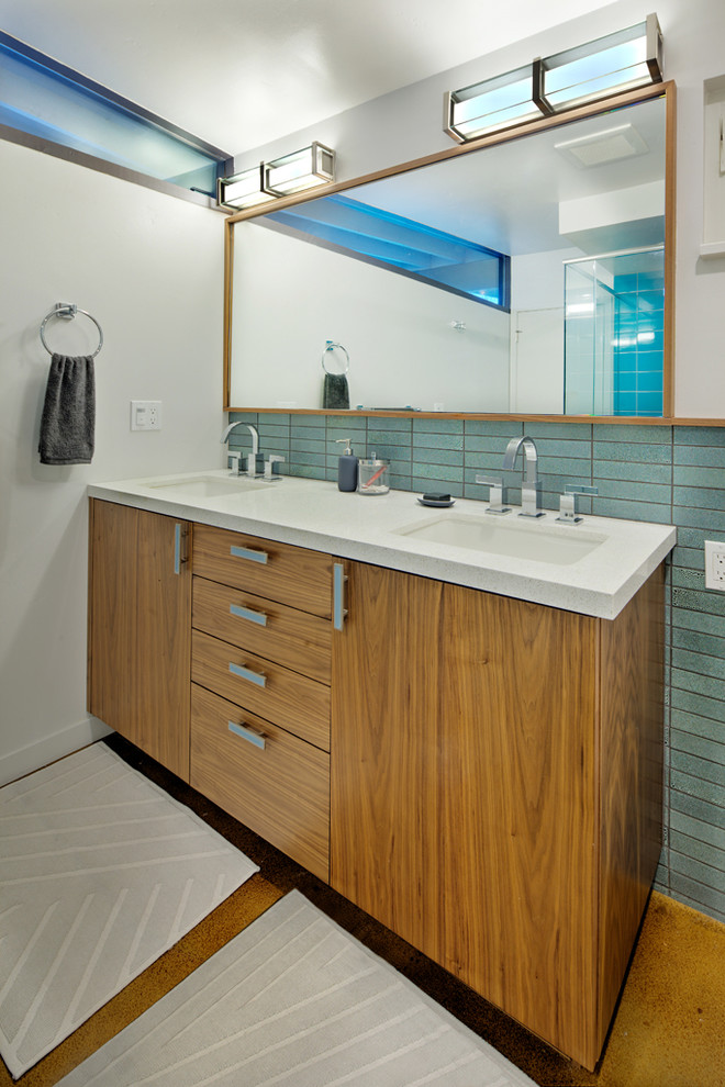 Cette image montre une salle de bain principale minimaliste en bois brun de taille moyenne avec un placard à porte plane, un carrelage bleu, des carreaux de céramique, un mur blanc, sol en béton ciré, un plan de toilette en quartz modifié et un lavabo encastré.