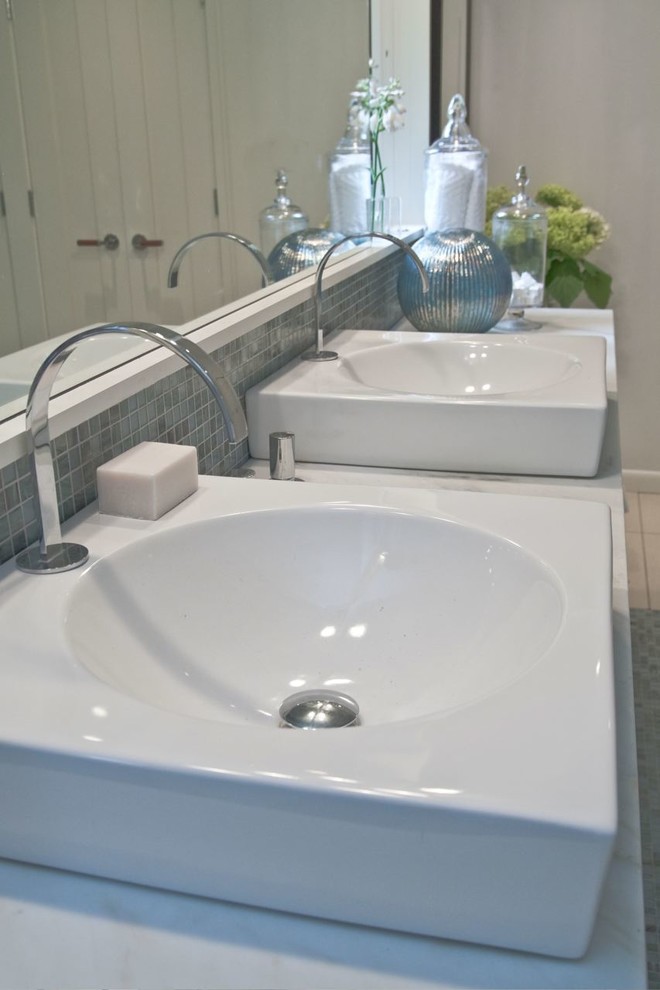 Diseño de cuarto de baño actual con lavabo sobreencimera, encimera de mármol y baldosas y/o azulejos azules