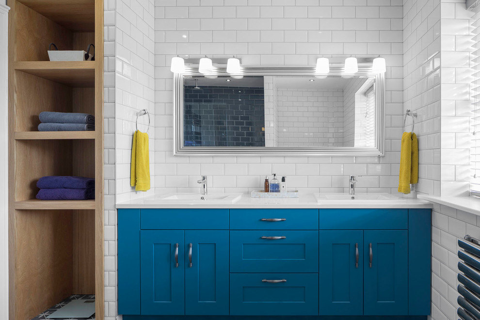 Modelo de cuarto de baño contemporáneo de tamaño medio con puertas de armario azules, baldosas y/o azulejos blancos, baldosas y/o azulejos de cemento, paredes blancas, lavabo integrado, encimera de mármol, encimeras blancas y armarios estilo shaker