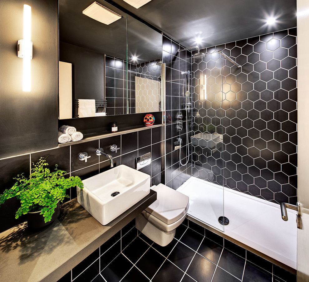 На фото: ванная комната в современном стиле с душем в нише, черной плиткой, настольной раковиной, открытым душем и зеркалом с подсветкой