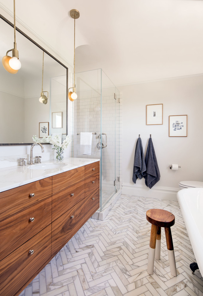 Inspiration for a large classic ensuite bathroom in San Francisco with flat-panel cabinets, dark wood cabinets, a corner shower, white tiles, ceramic tiles, white walls, marble worktops, a hinged door, a submerged sink and white floors.