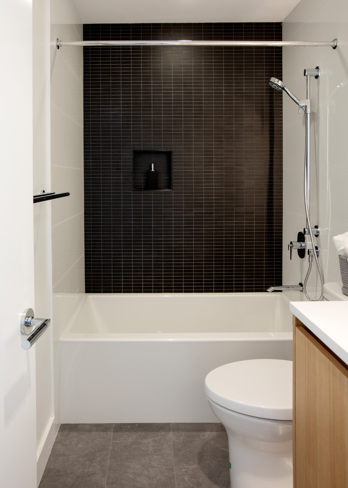 Стильный дизайн: главная ванная комната среднего размера в стиле модернизм с плоскими фасадами, черной плиткой, столешницей из кварцита, белой столешницей, ванной в нише, душем в нише, унитазом-моноблоком, керамической плиткой, белыми стенами, полом из керамической плитки, врезной раковиной, серым полом, шторкой для ванной и светлыми деревянными фасадами - последний тренд