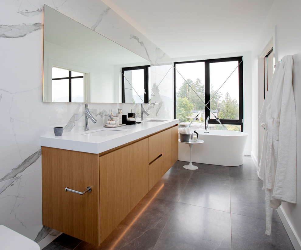 Exempel på ett stort modernt vit vitt en-suite badrum, med släta luckor, en dusch i en alkov, en toalettstol med hel cisternkåpa, vita väggar, klinkergolv i porslin, ett undermonterad handfat, grått golv, dusch med duschdraperi, ett fristående badkar, skåp i mellenmörkt trä, vit kakel, stenhäll och bänkskiva i akrylsten