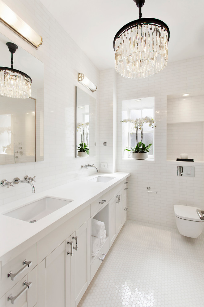 На фото: ванная комната в стиле неоклассика (современная классика) с врезной раковиной, фасадами в стиле шейкер, белыми фасадами, инсталляцией, белой плиткой, полом из мозаичной плитки и зеркалом с подсветкой с